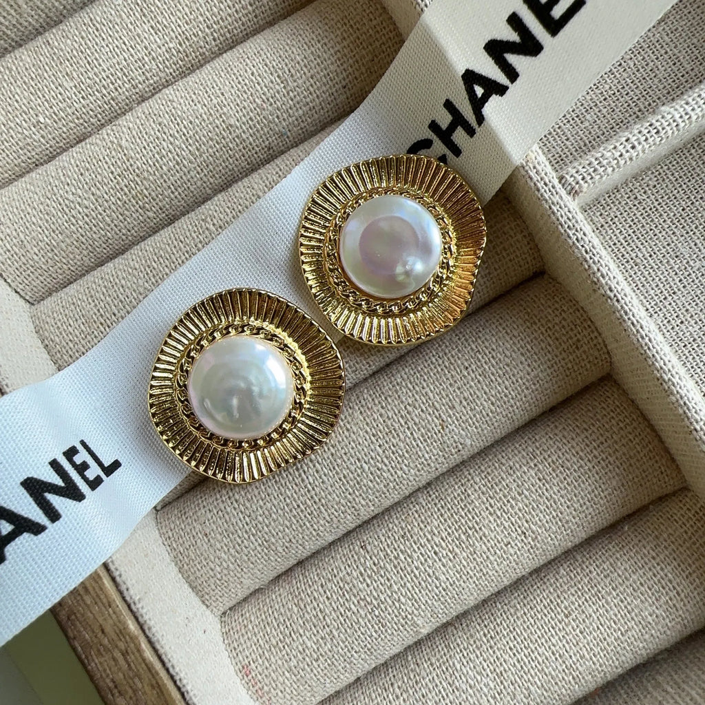 A pair of round gold-coloured retro style metal earrings for women.