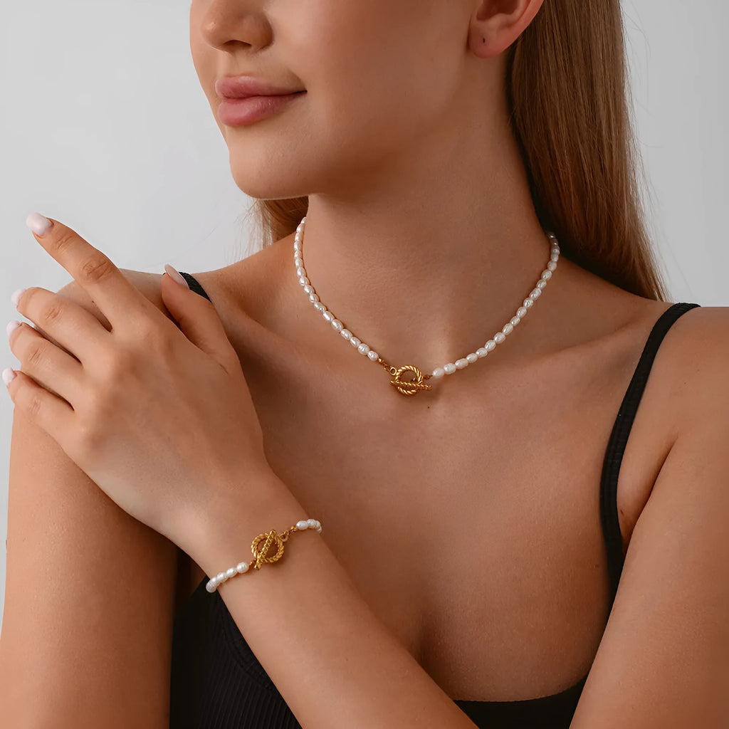 Freshwater pearl and stainless steel geometric pendant necklace and matching bracelet set for women.