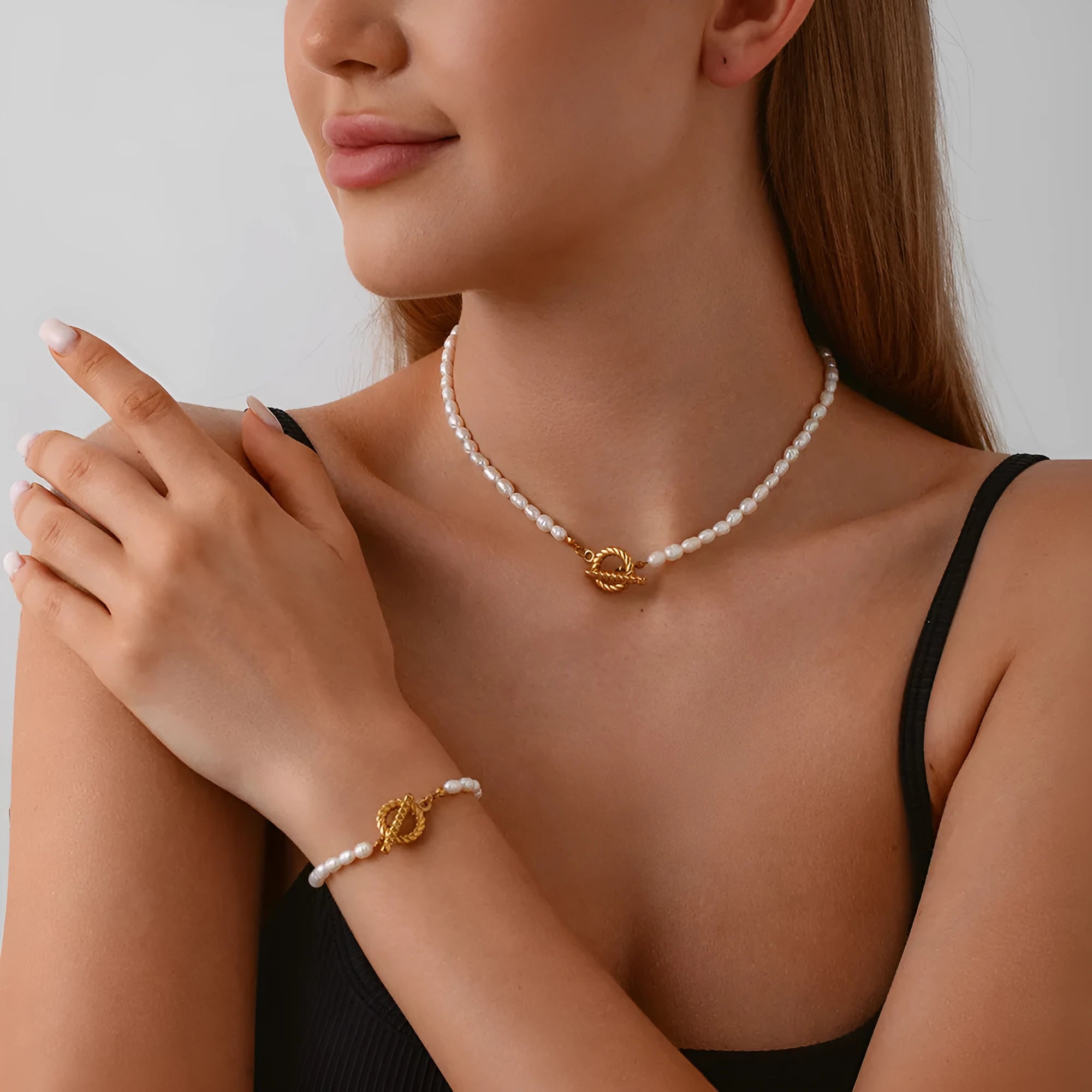 Freshwater pearl and stainless steel geometric pendant necklace and matching bracelet set for women.