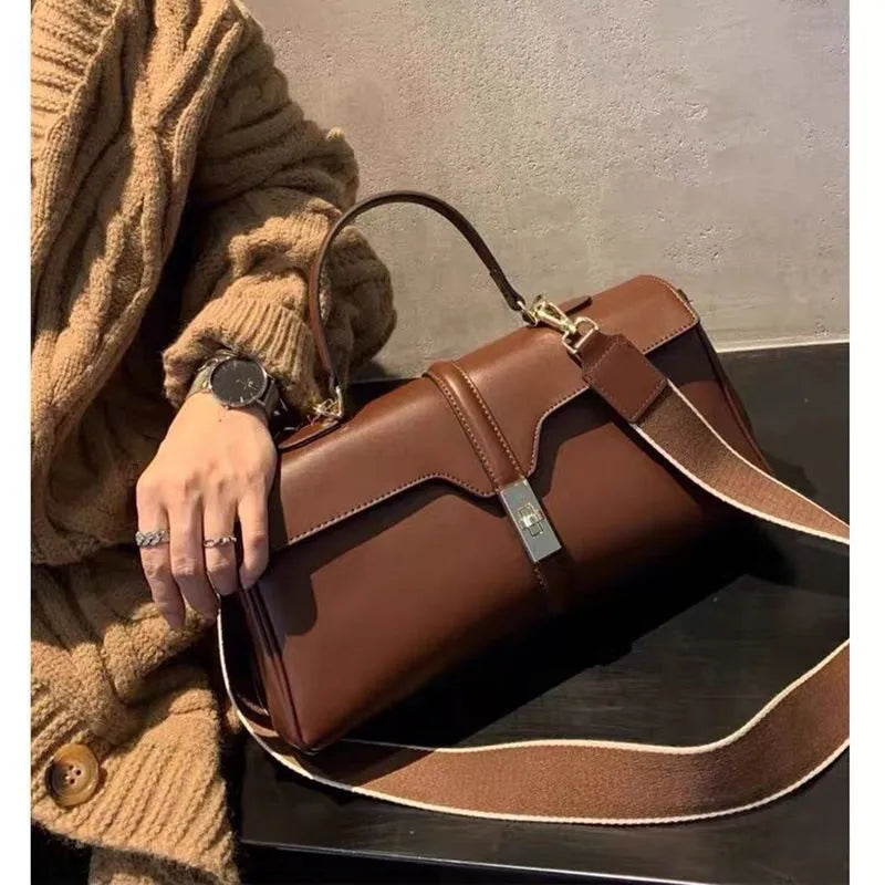 Women's cylindrical cowhide leather messenger bag in black or caramel colour with retro styling