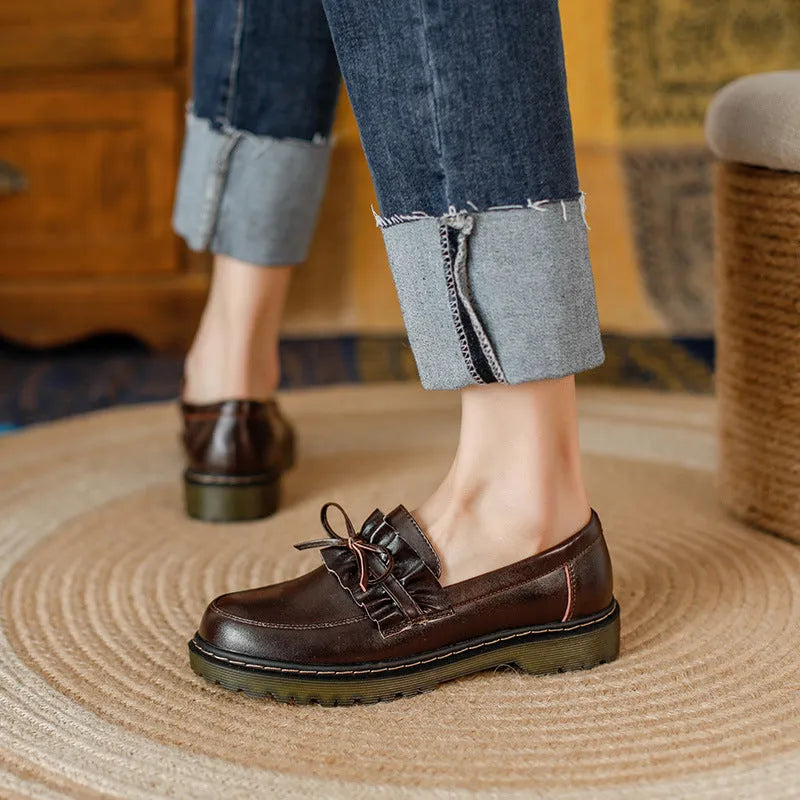 Women's black leather shoes with round toe and chunky flat heel in British style.