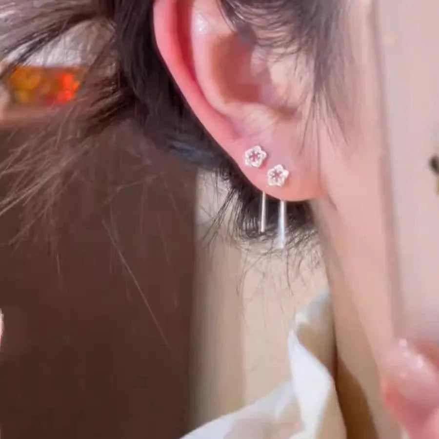 Silver hollow flower stud earrings with natural petal design on alloy backing