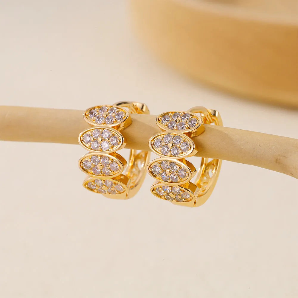 Gold-coloured women's stud earrings with zircon stone detailing on zirconium settings