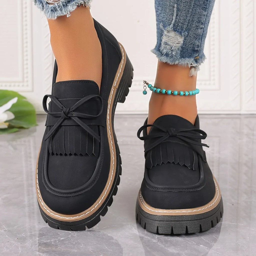 Women's black plus size loafers with tassel and bowknot, chunky heel, and round toe on a rubber sole