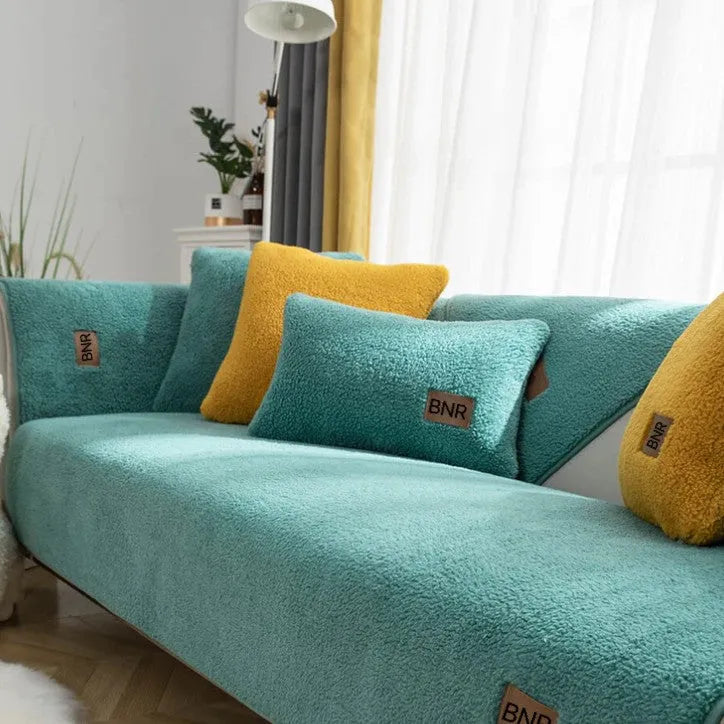 Lambswool sofa cover in blue colour on a grey sofa, showing simple solid colour design