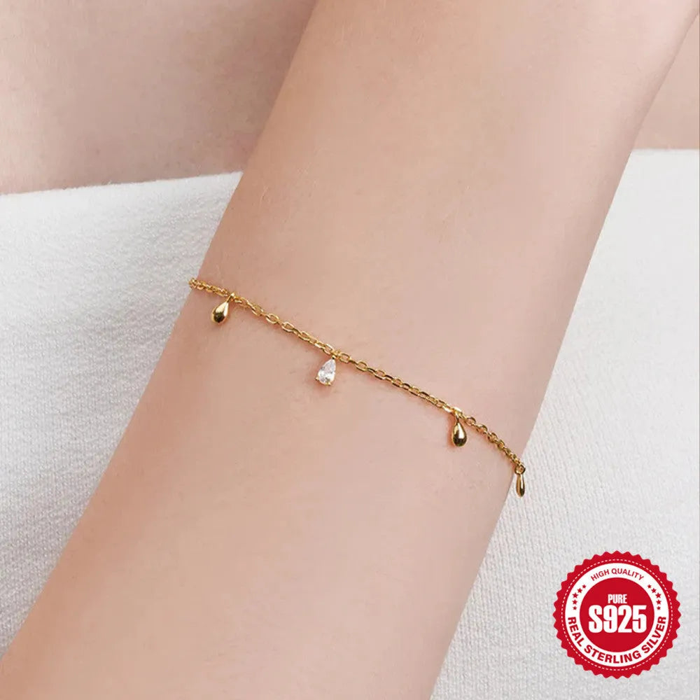 S925 sterling silver bracelet with gold colour finish and a geometric water drop diamond pendant.