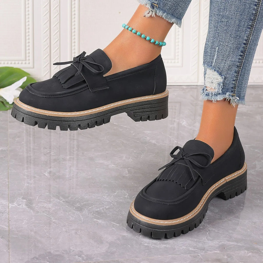 Women's black plus size loafers with tassel and bowknot, chunky heel, and round toe on a rubber sole