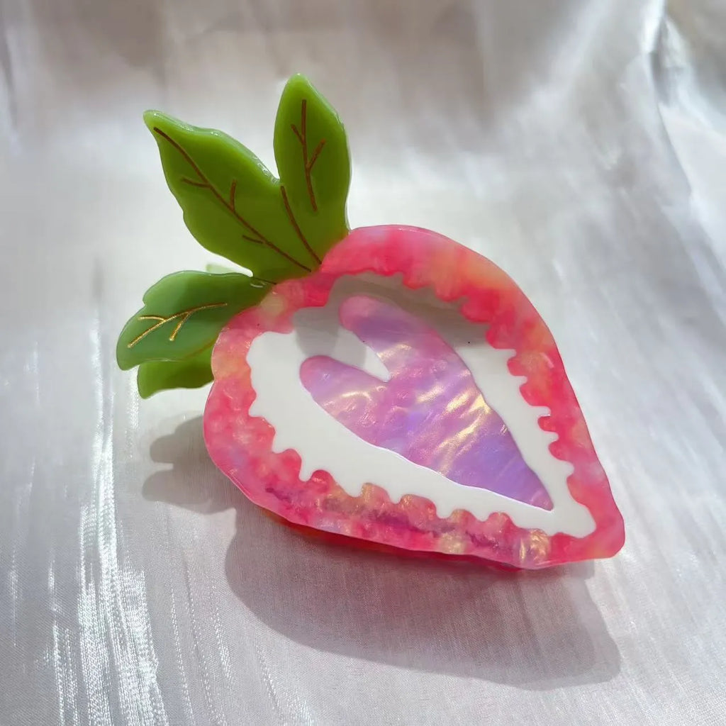 Handmade red strawberry hairpin with pastoral style design on a pink background