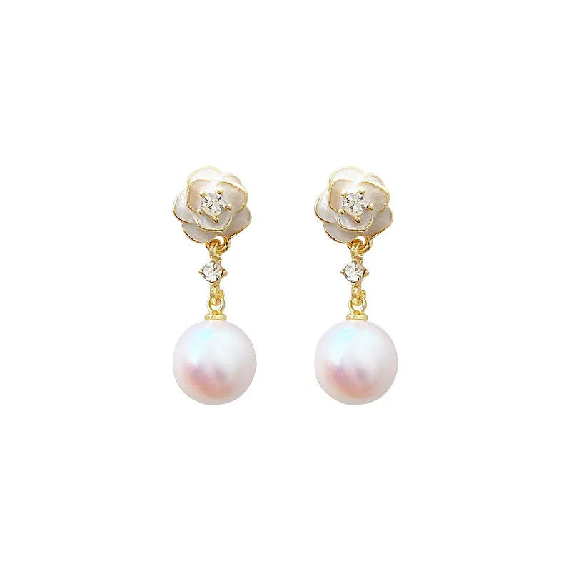 Close-up of camellia flower-shaped stud earrings for women in a pearl-like finish.