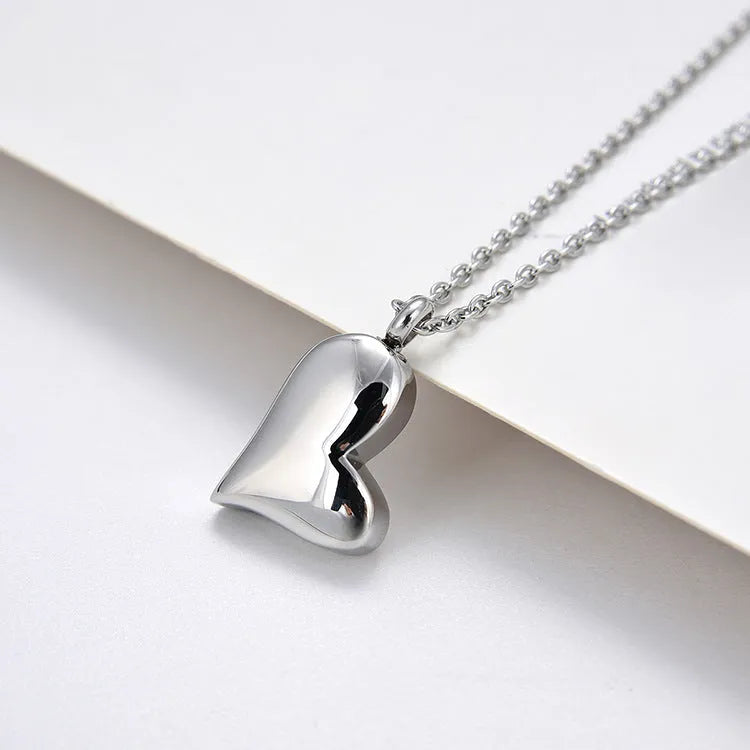 Silver curved peach heart pendant on adjustable stainless steel necklace, 51cm chain with 5cm extension