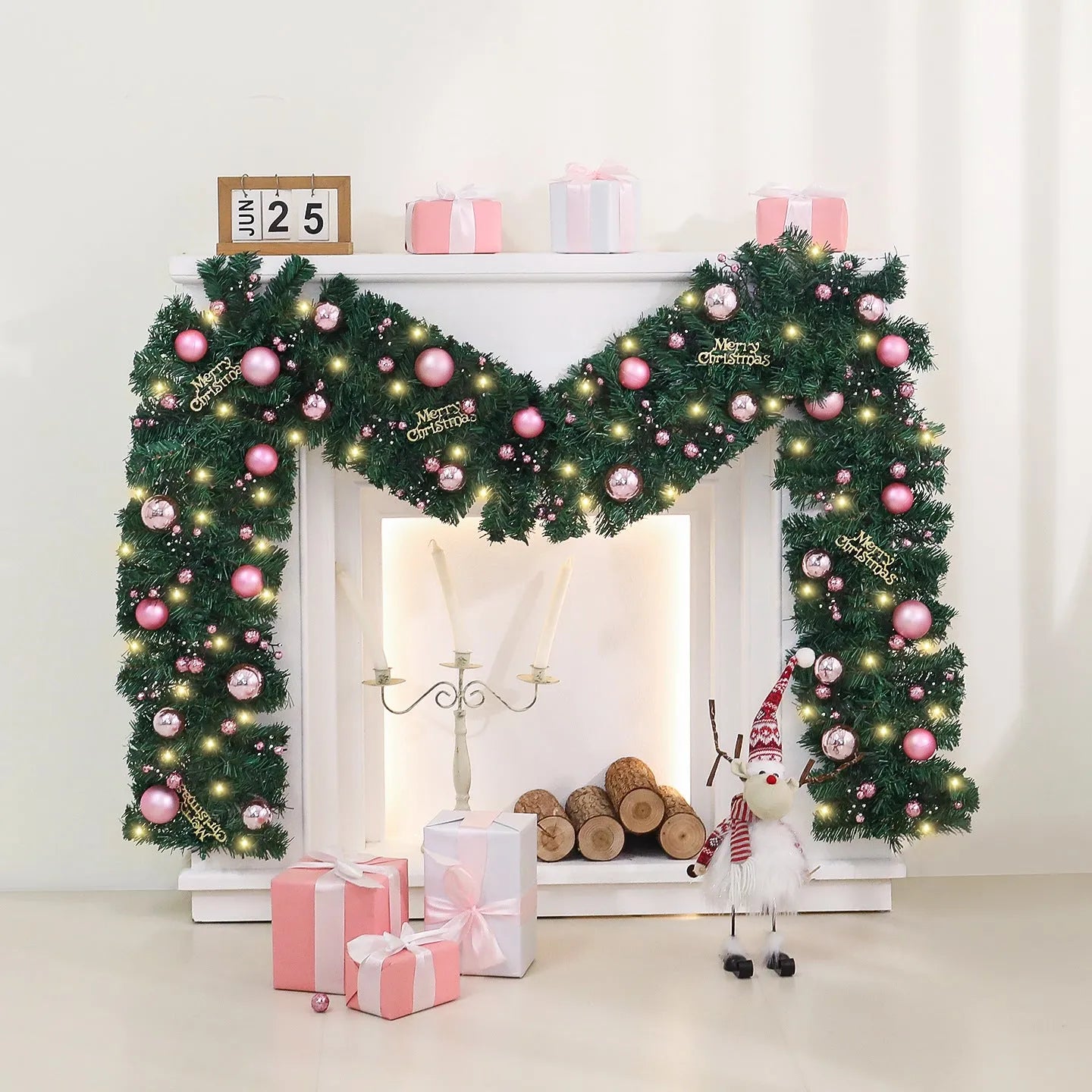 Pink rattan Christmas vine decoration with small fruit ornaments, 2.7 metres long, on a wall display