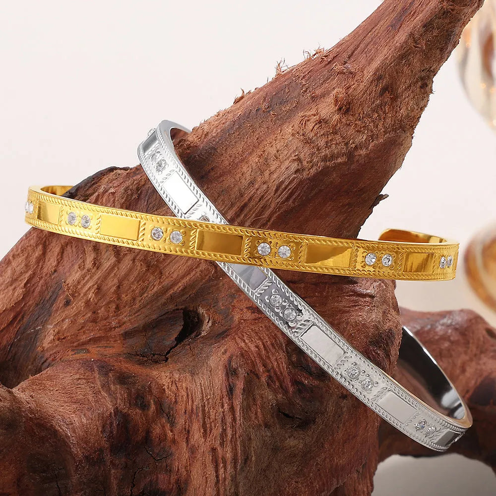 Stainless steel open-end bracelet with a buckle closure and circle design, shown in an electroplated gold colour.