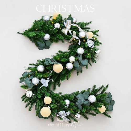 Long artificial rattan Christmas vine with green and white PE leaves and integrated fairy lights.