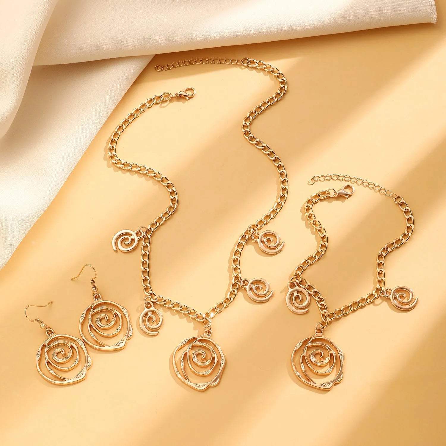 Spiral donut jewellery set with necklace, bracelet, and earrings in gold electroplated alloy