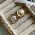 A pair of round gold-coloured retro style metal earrings for women.