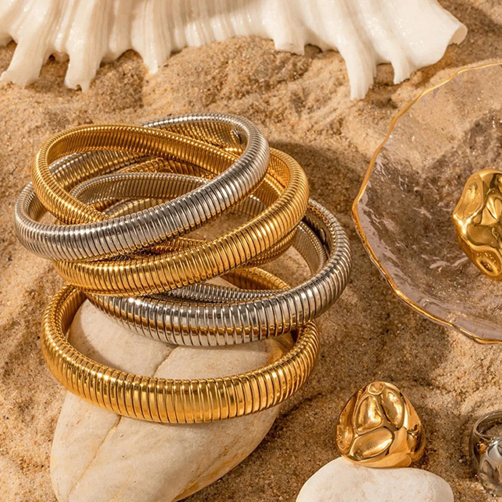 Women's elastic titanium steel bracelet with vertical stripe and ring design in gold or silver, showing adjustable width options.