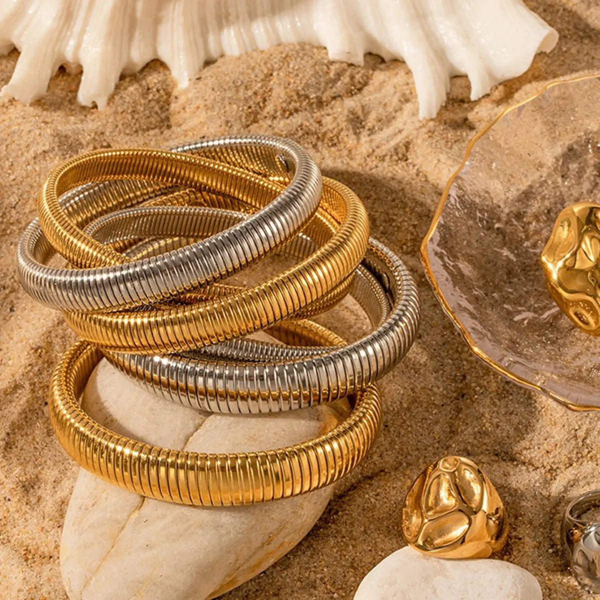 Women's elastic titanium steel bracelet with vertical stripe and ring design in gold or silver, showing adjustable width options.