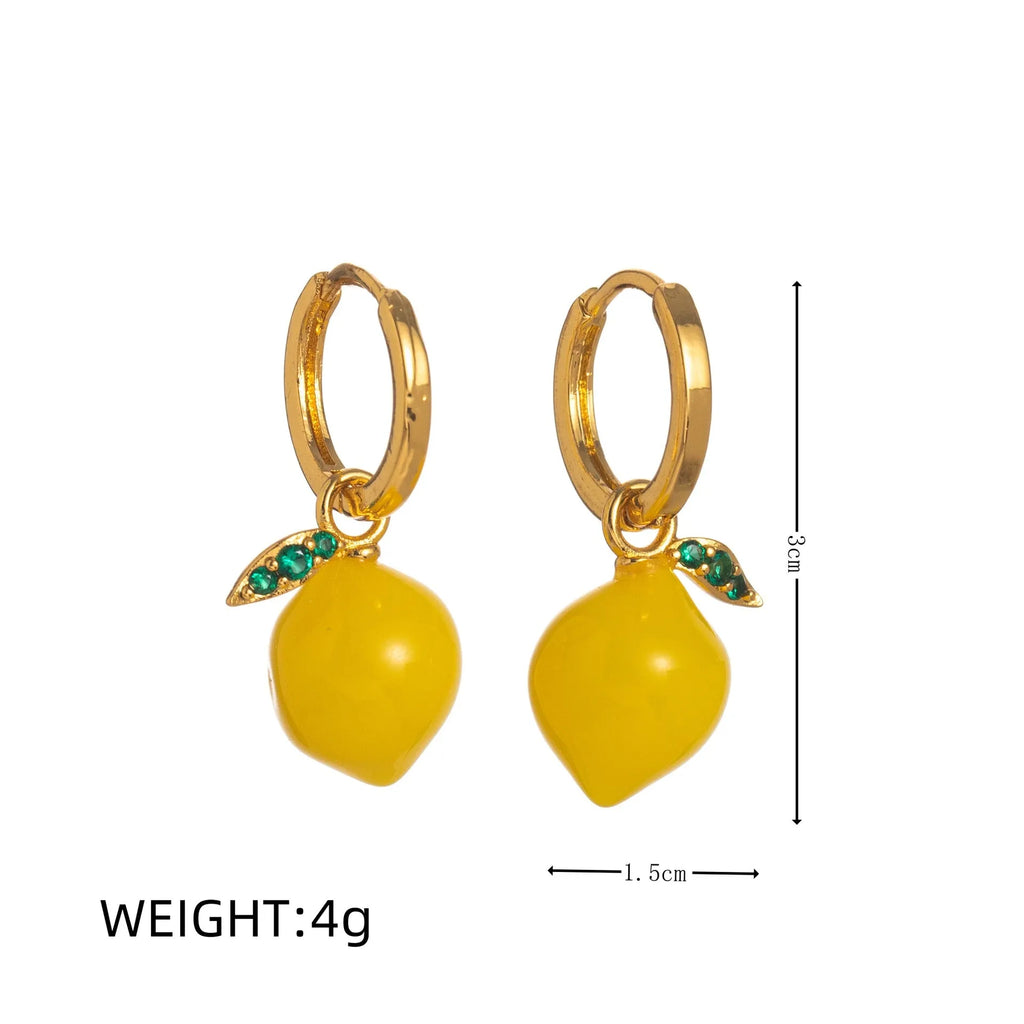 Gold plated copper earrings shaped like carrots, lemons, blueberries, olives, oranges, peaches, and chillies.