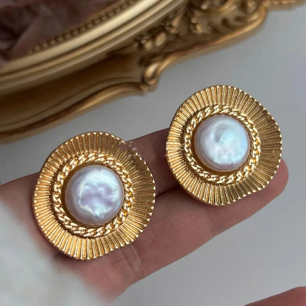 A pair of round gold-coloured retro style metal earrings for women.