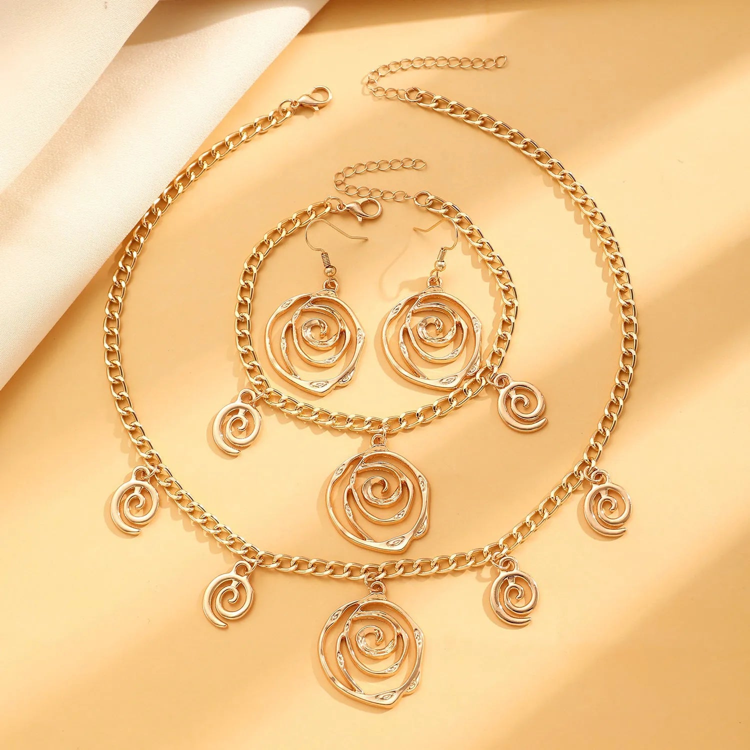 Spiral donut jewellery set with necklace, bracelet, and earrings in gold electroplated alloy