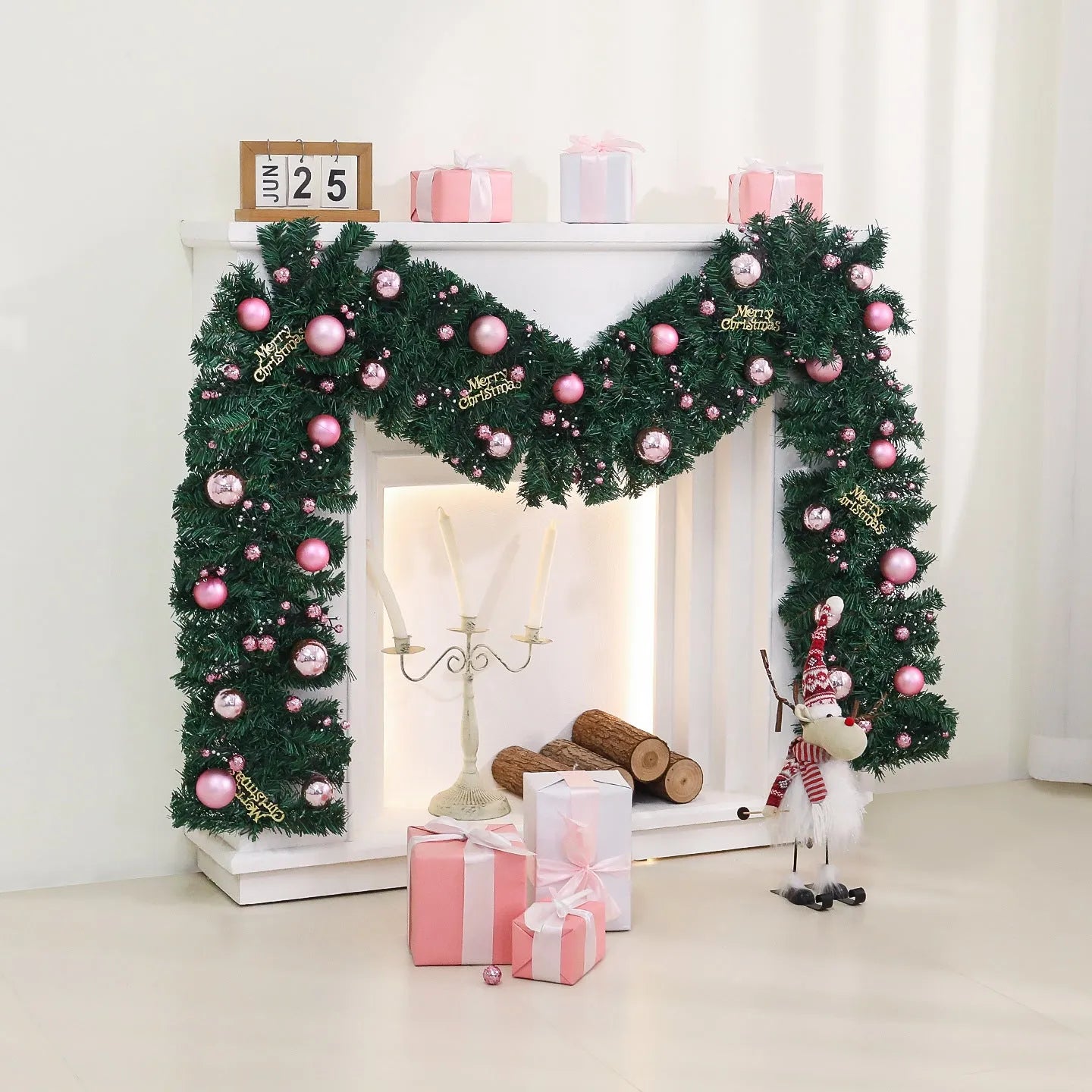 Pink rattan Christmas vine decoration with small fruit ornaments, 2.7 metres long, on a wall display