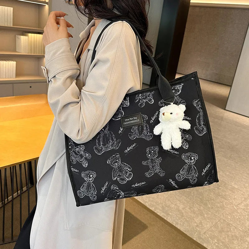 Women's black canvas tote with rhombus pattern showing 40cm width and horizontal square shape with shoulder strap