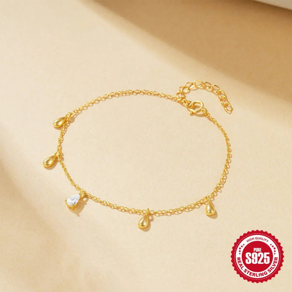S925 sterling silver bracelet with gold colour finish and a geometric water drop diamond pendant.