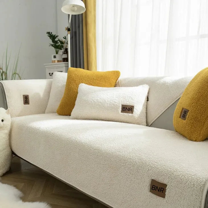 Lambswool sofa cover in blue colour on a grey sofa, showing simple solid colour design