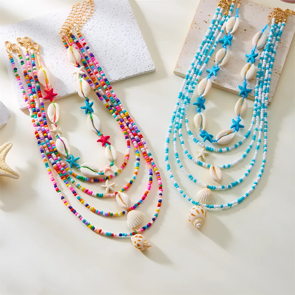 Blue and multi-colour women's multi-layer necklace set with shell, conch, and starfish bead pendants on a white background.
