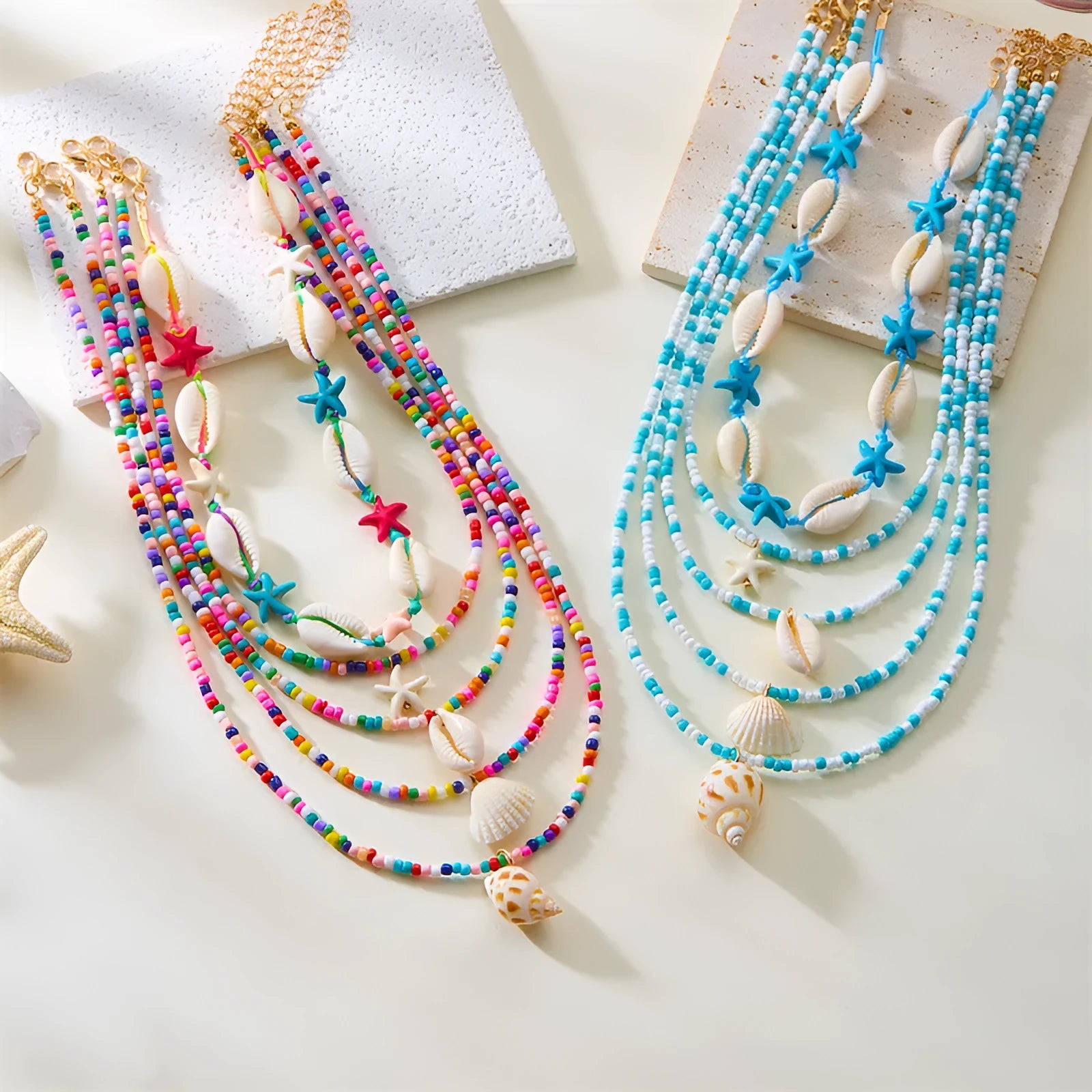 Blue and multi-colour women's multi-layer necklace set with shell, conch, and starfish bead pendants on a white background.