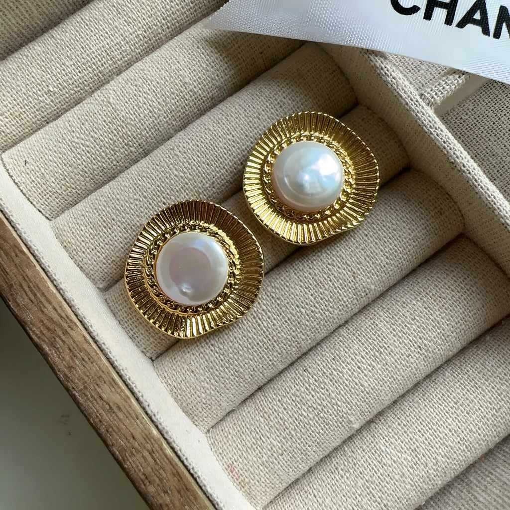 A pair of round gold-coloured retro style metal earrings for women.