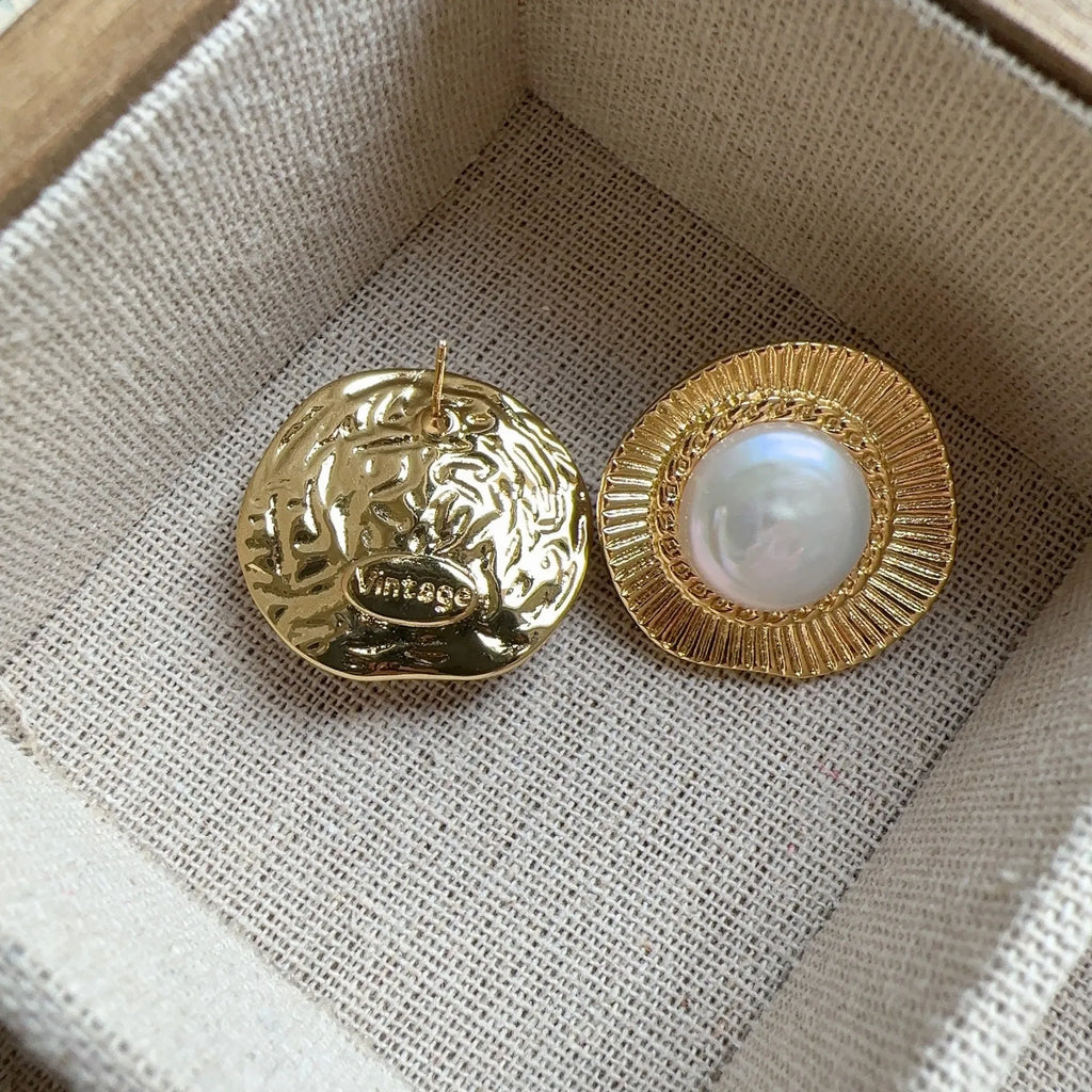A pair of round gold-coloured retro style metal earrings for women.