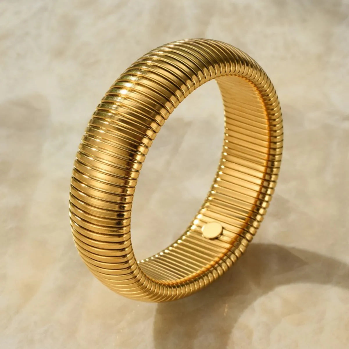 Women's elastic titanium steel bracelet with vertical stripe and ring design in gold or silver, showing adjustable width options.