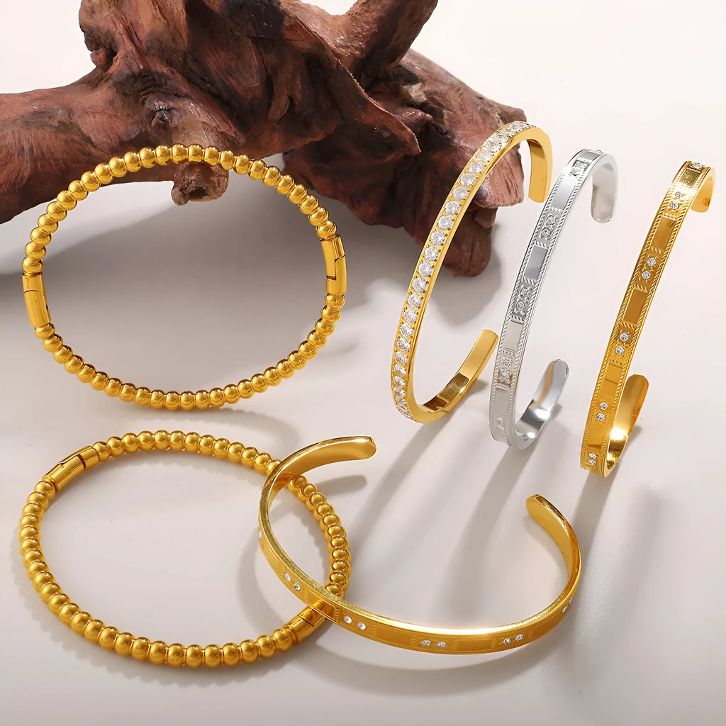 Stainless steel open-end bracelet with a buckle closure and circle design, shown in an electroplated gold colour.