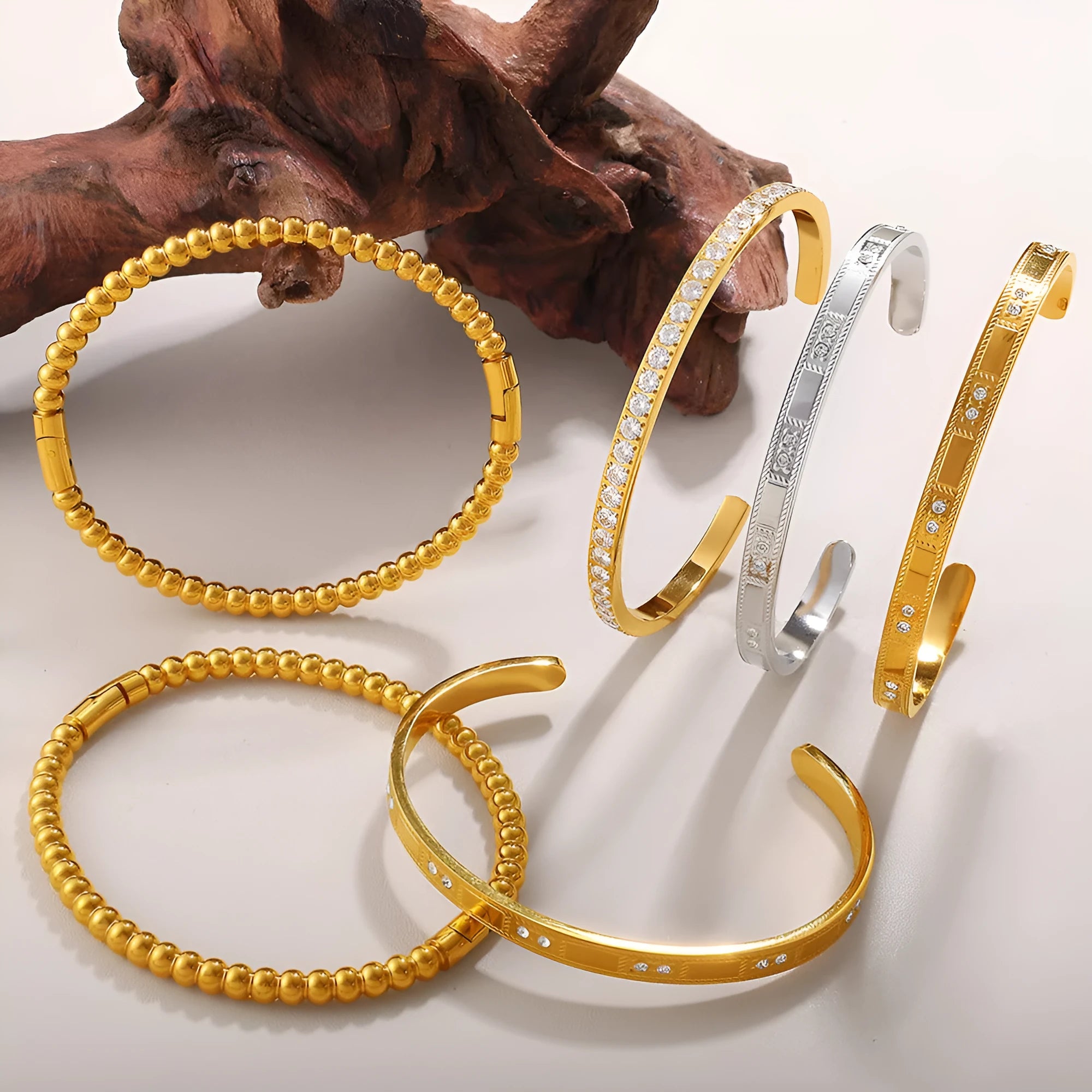 Stainless steel open-end bracelet with a buckle closure and circle design, shown in an electroplated gold colour.