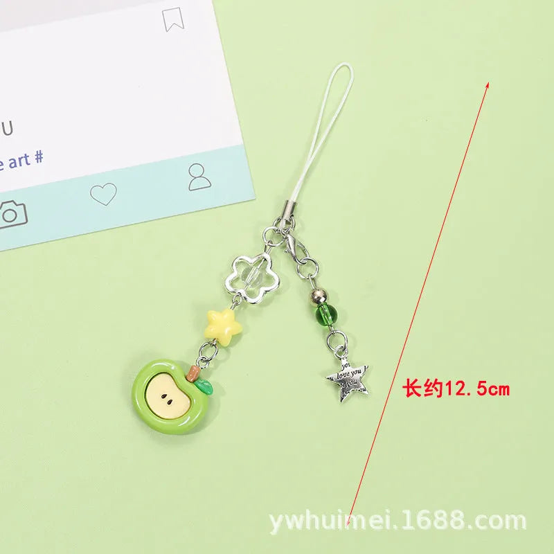 Red and green fruit-themed plastic mobile phone charm and keychain on a white background.