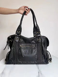 Women's retro messenger bag in bright black with golden edge, showing internal zipper compartments and weaving details