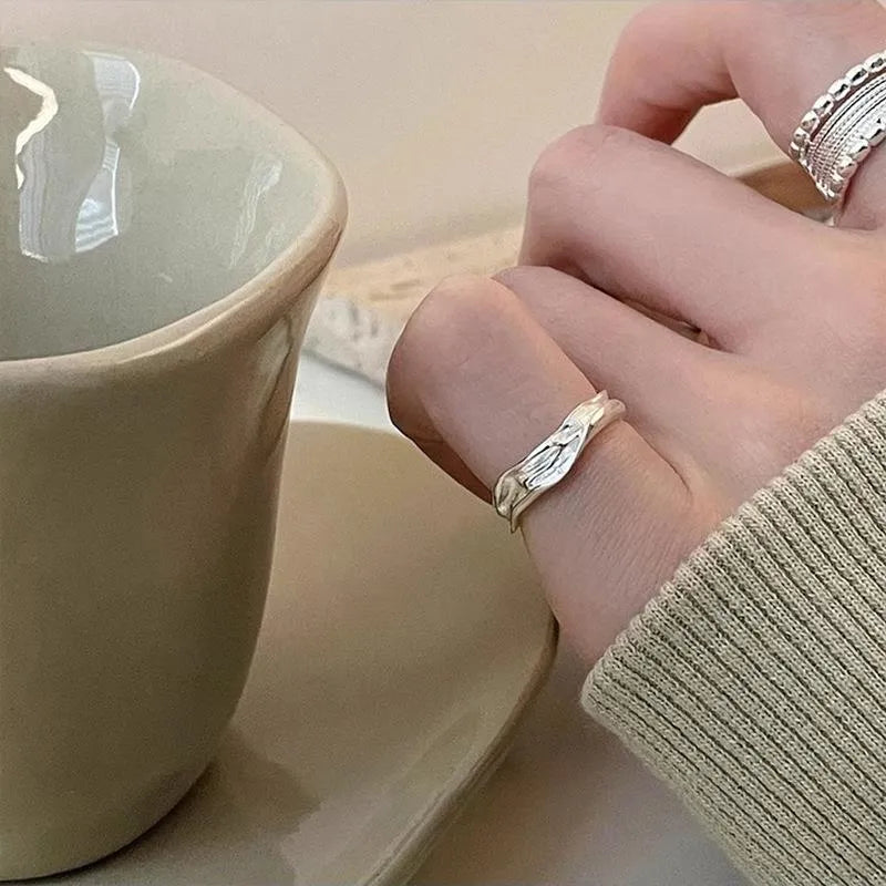 Close-up of an adjustable woven twisted multilayer copper ring with a geometric shape.