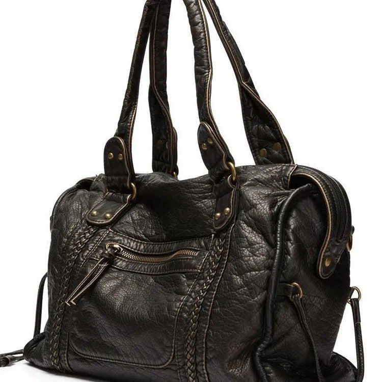 Women's retro messenger bag in bright black with golden edge, showing internal zipper compartments and weaving details