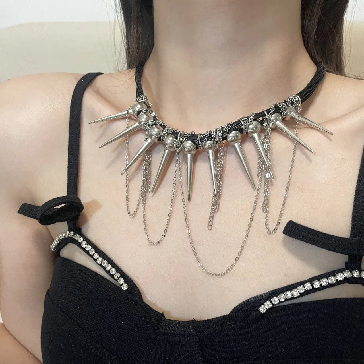 Leather necklace with winding tassel, round beads, and metallic rivet details in a picture colour.