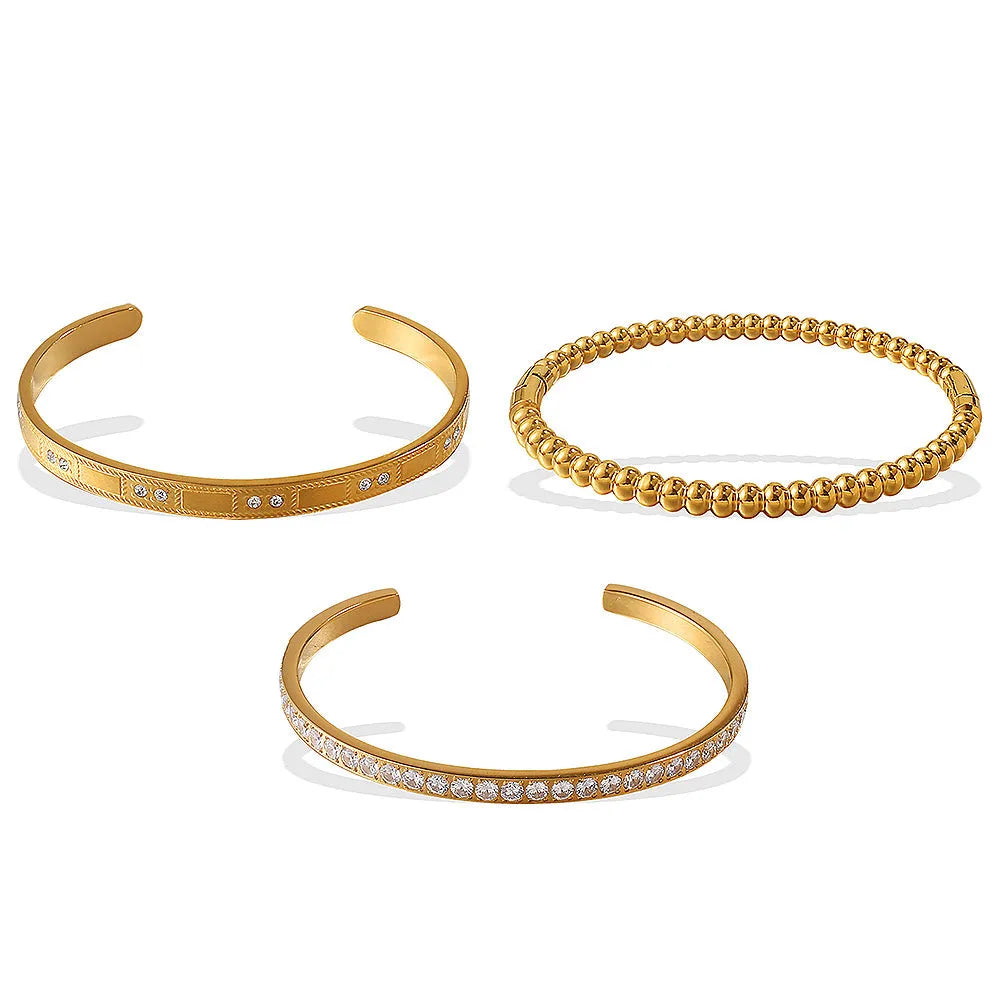 Stainless steel open-end bracelet with a buckle closure and circle design, shown in an electroplated gold colour.