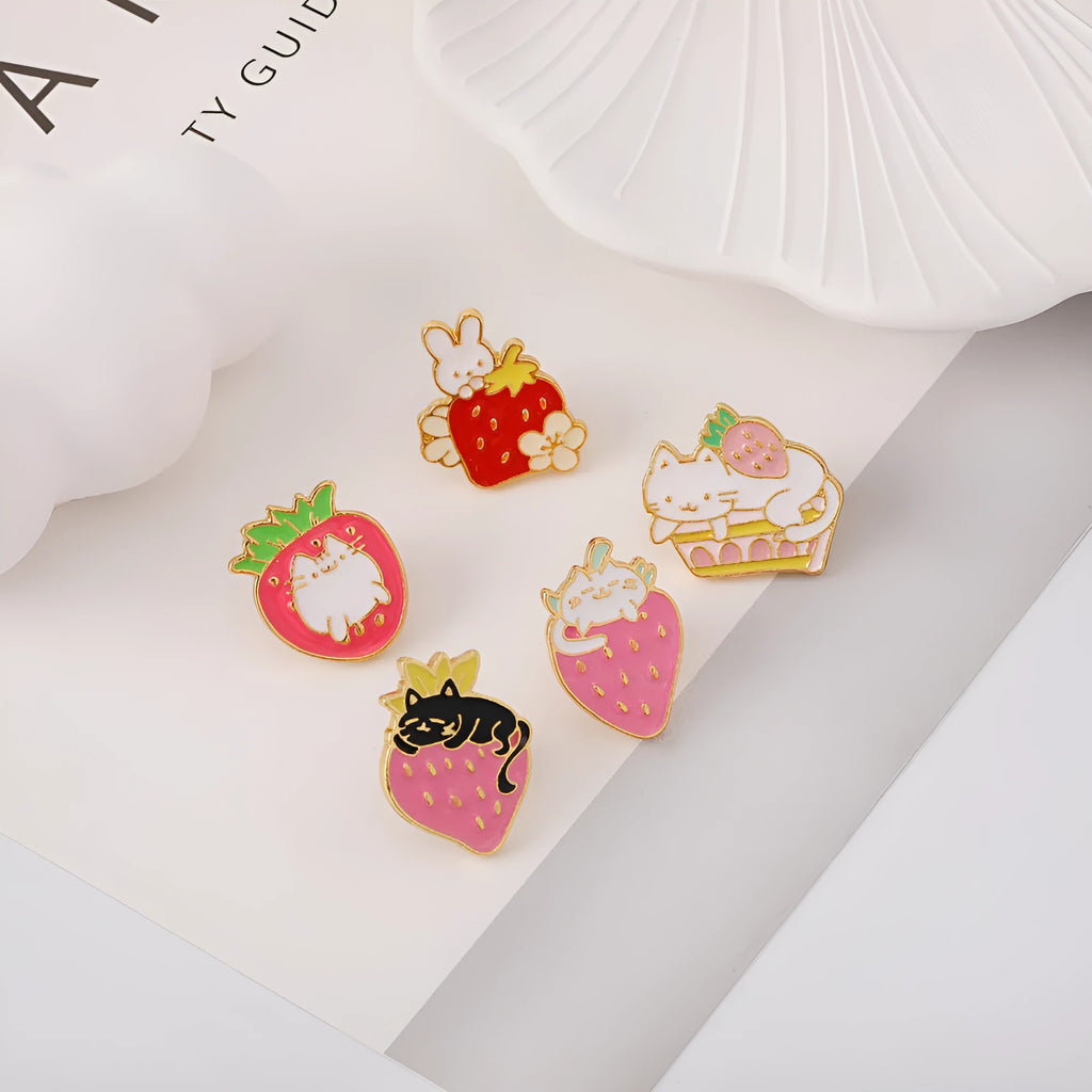 Alloy brooch with a cute cat, strawberry, and dripping oil design in metallic colours.