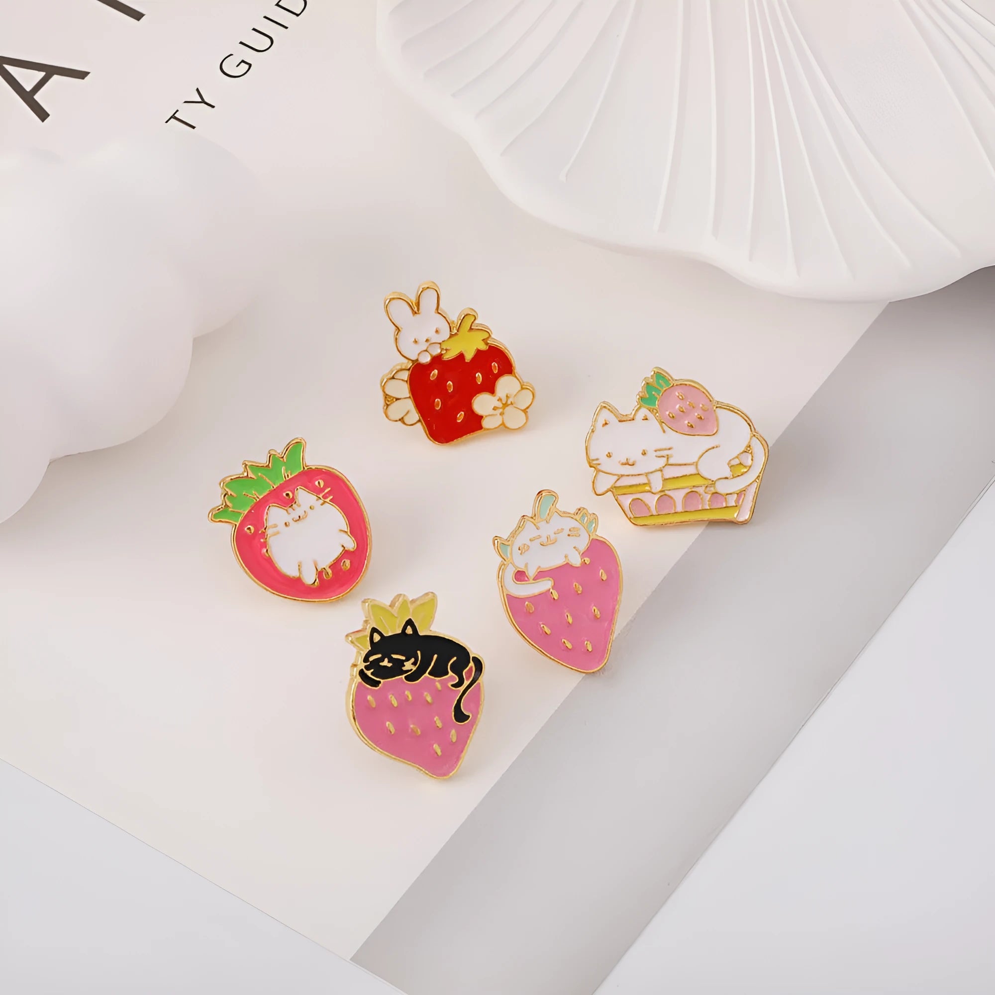 Alloy brooch with a cute cat, strawberry, and dripping oil design in metallic colours.