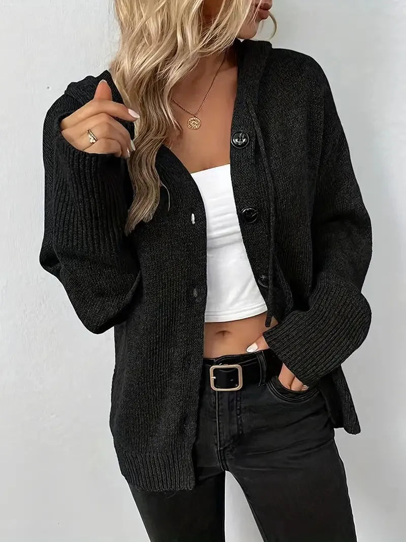 A thick grey cotton hooded cardigan sweater on a hanger, showing its single-breasted front and long sleeves.