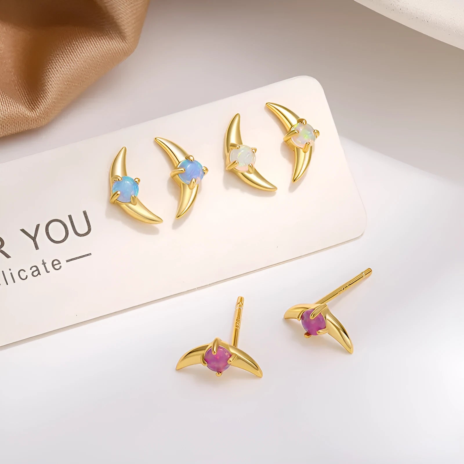 Women's geometric earrings in 925 silver with electroplated finish, showing colour options with blue, purple, and white stones.