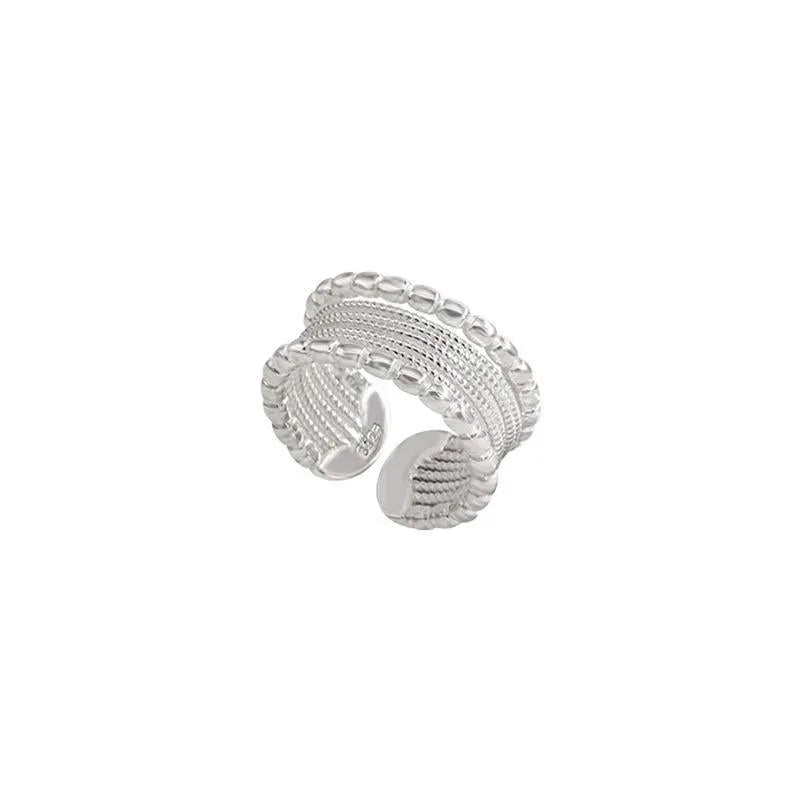 Close-up of an adjustable woven twisted multilayer copper ring with a geometric shape.