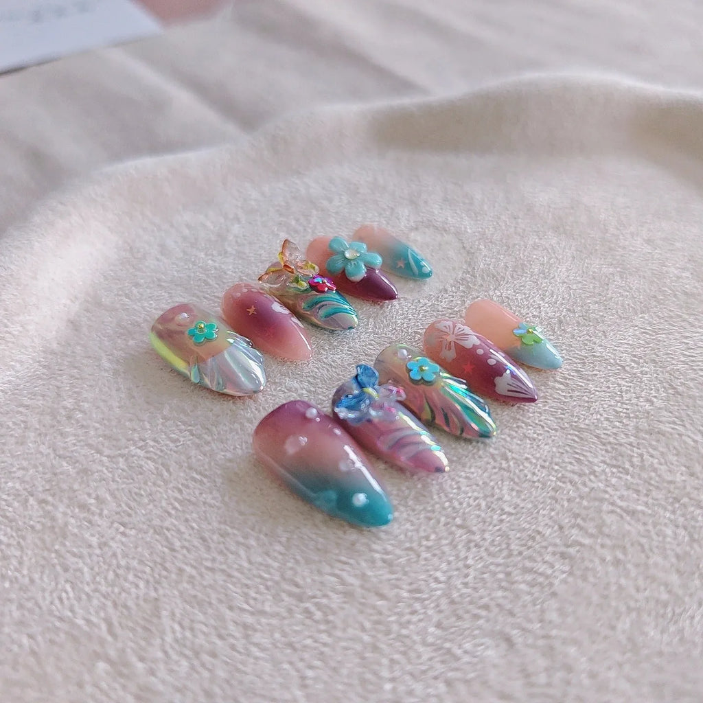 Handmade manicure sculptures showing embossed floral and butterfly patterns in four sizes (XS, S, M, L) for nail art