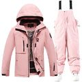 Men's and women's winter ski suit in blue top with grey-blue pants, showing waterproof construction for snow sports