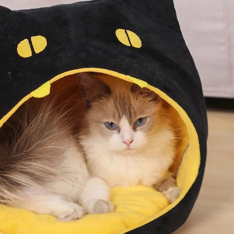 Grey covered cat cave pet bed with cat face design and anti-slip bottom.