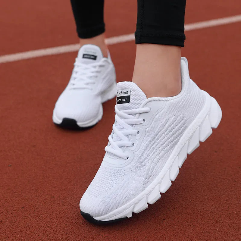 Women's low-cut black and white casual running sneakers with cross-strap detail and a lightweight MD sole.